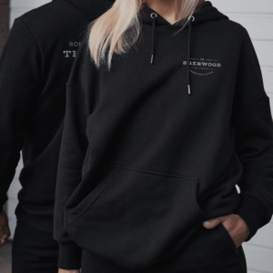 man and woman wearing sherwood black hoodies with chest logo